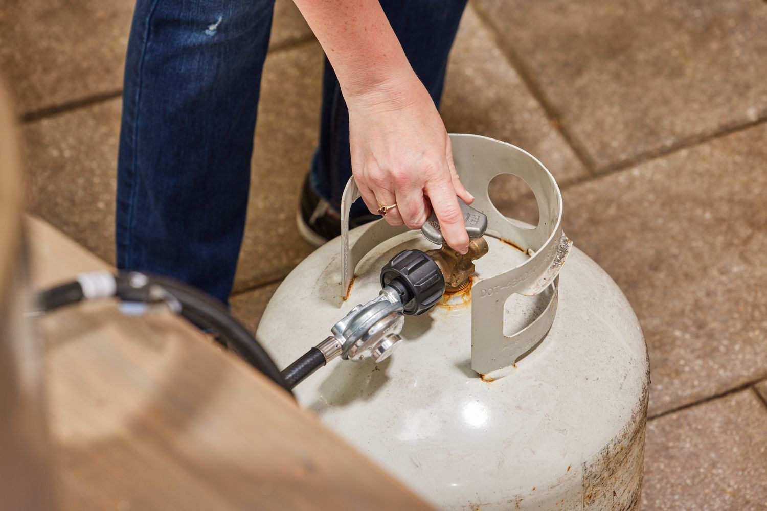 A person turning on the fuel tank for the Solo Stove Pi Prime Pizza Oven