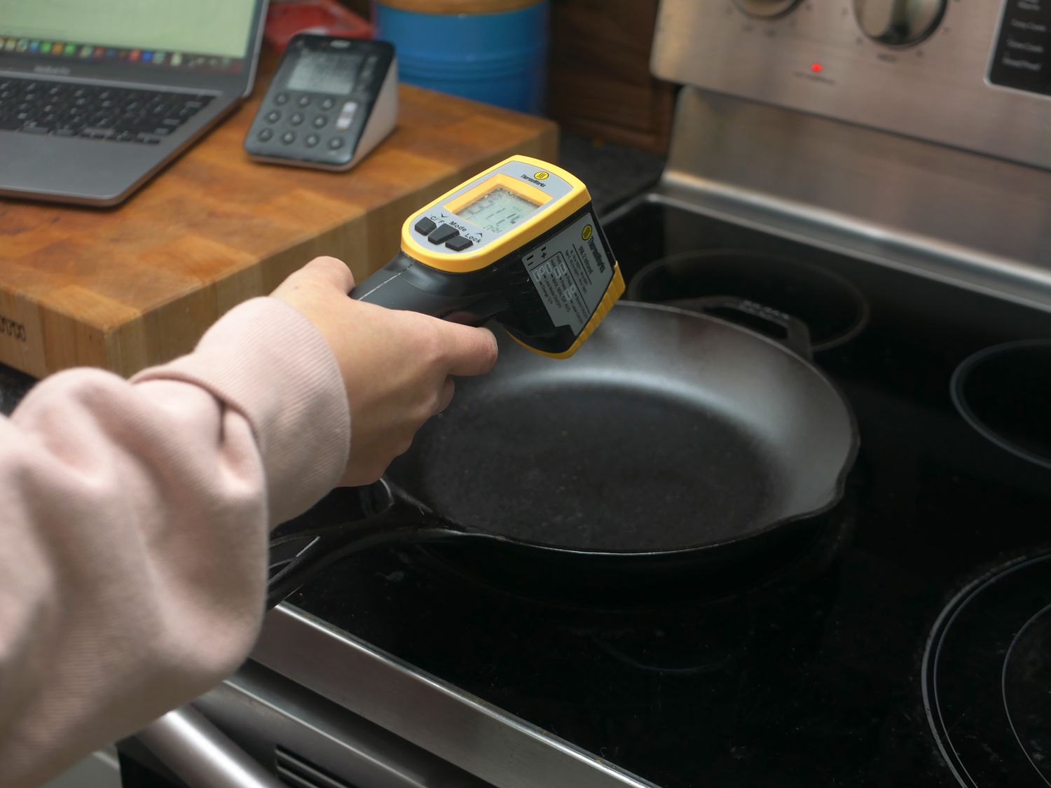 using an infrared thermometer to take the temperature of a skillet