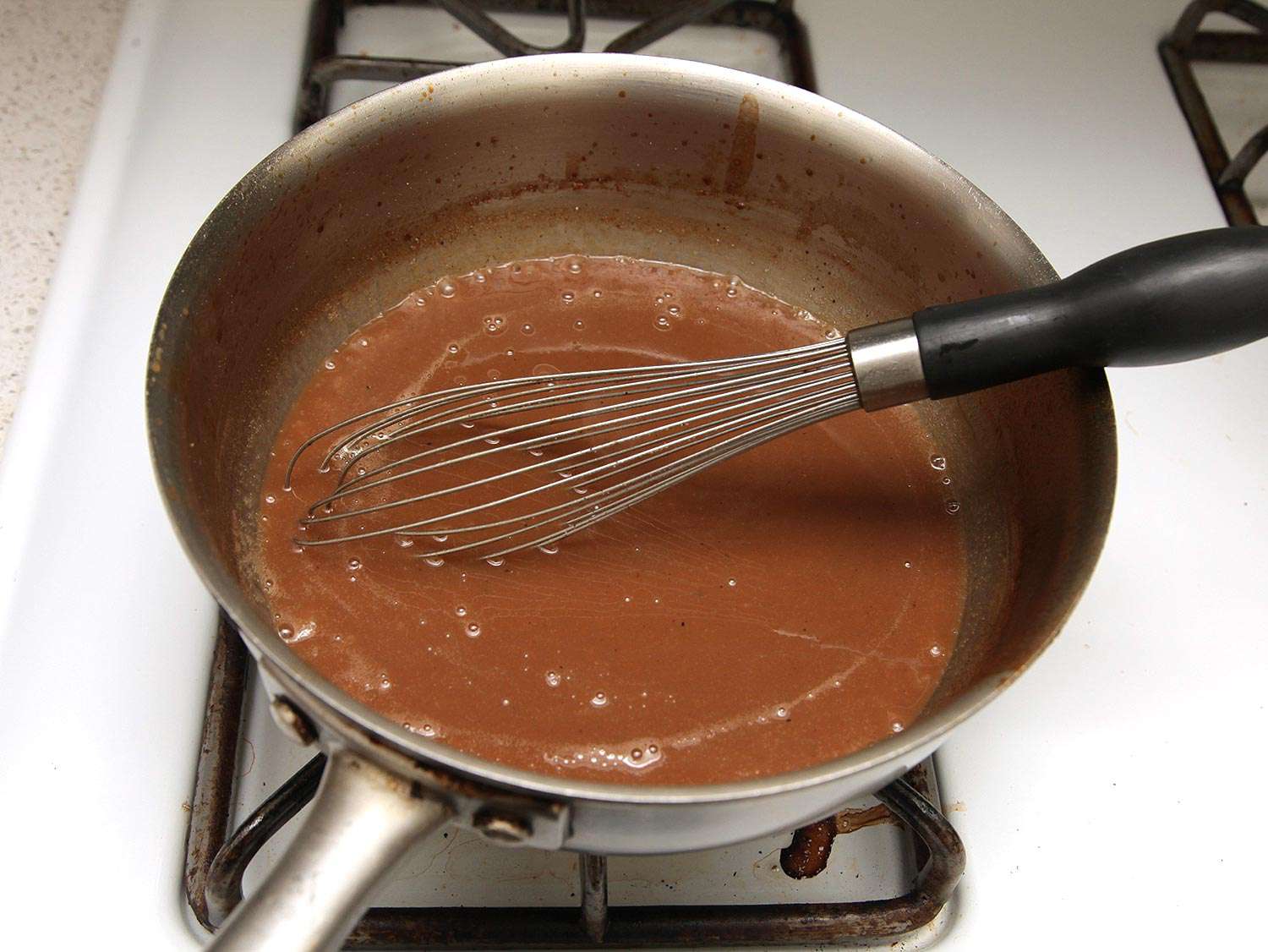 Gravy thickening in a saucepan. 