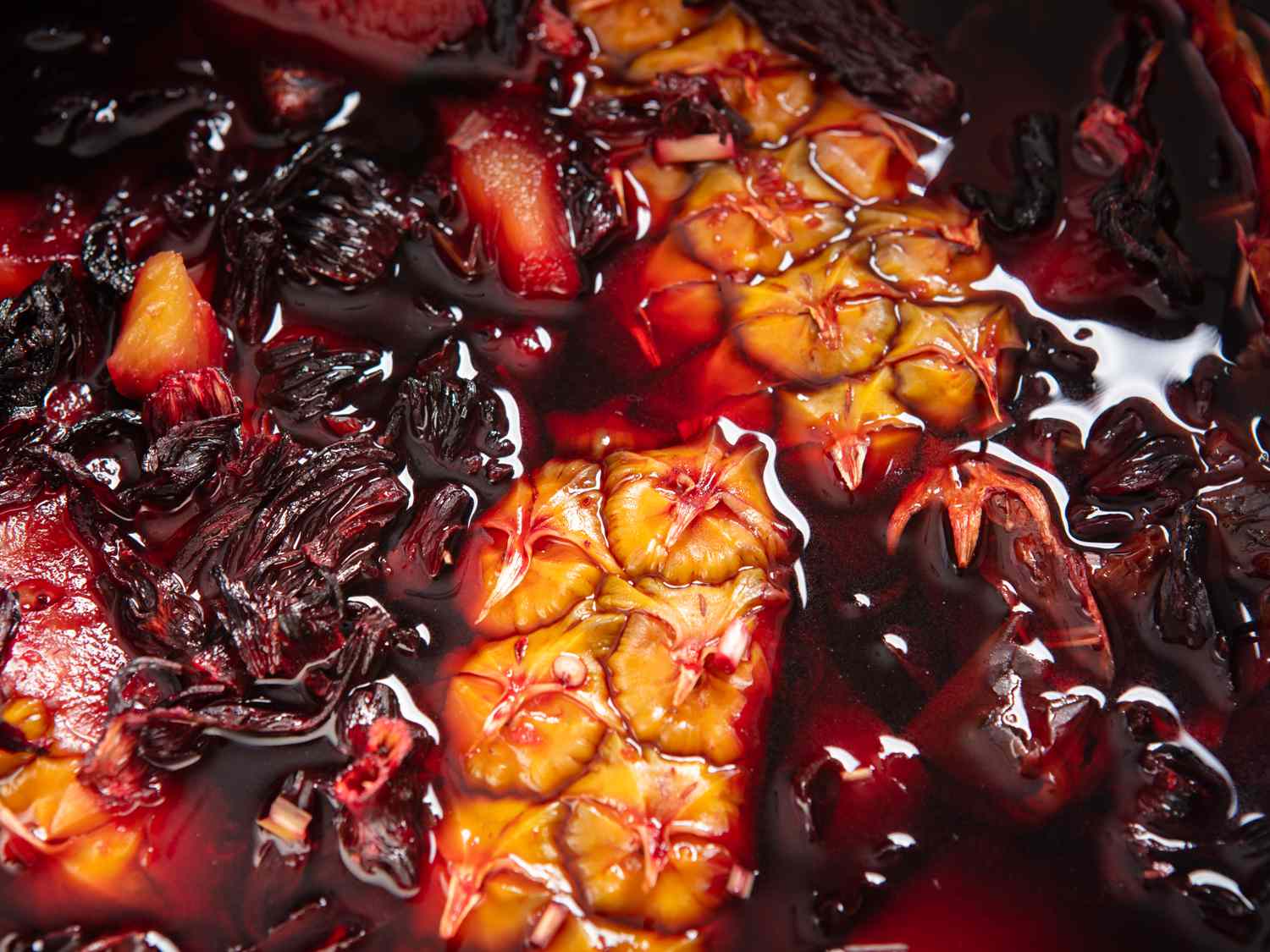 Pineapple skins, spices, and hibiscus leaves steeping in water