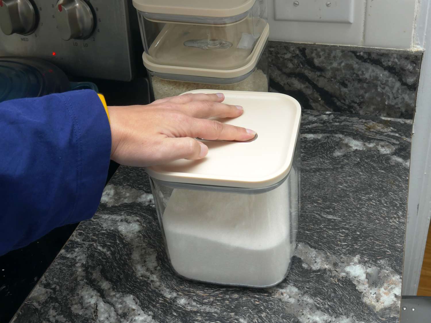 a person pressing the vacuum seal button on the caraway lids