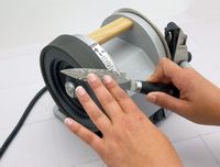 a person using the honing wheel to hone a paring knife