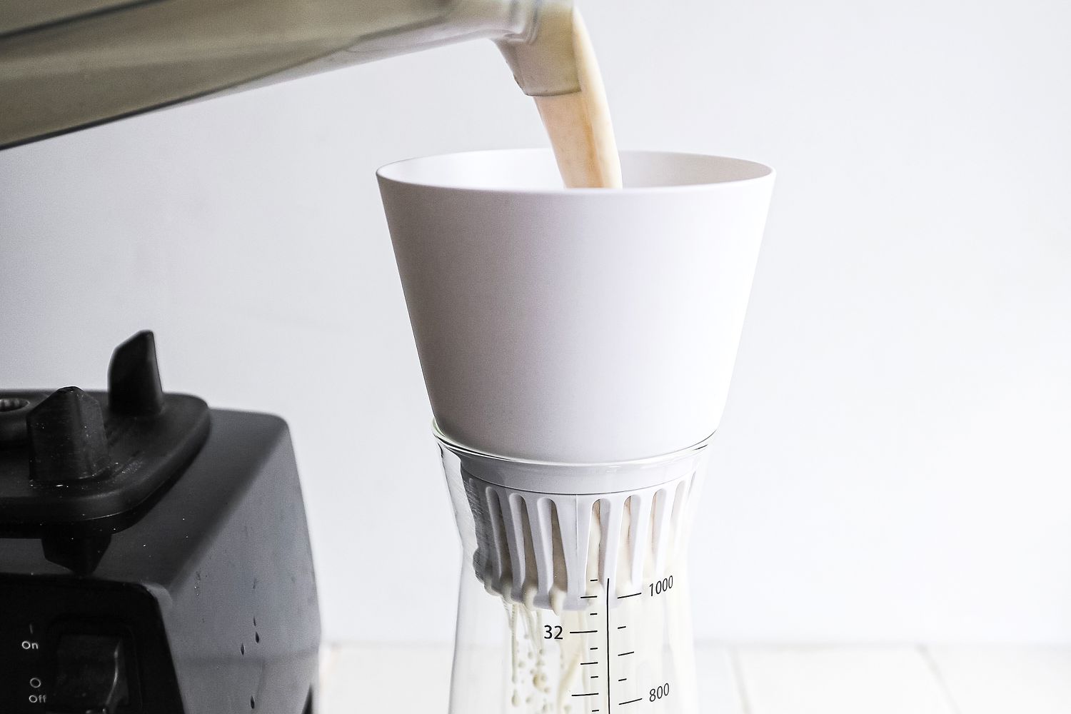 pouring blended nut and water mixture into the chefn strainer portion
