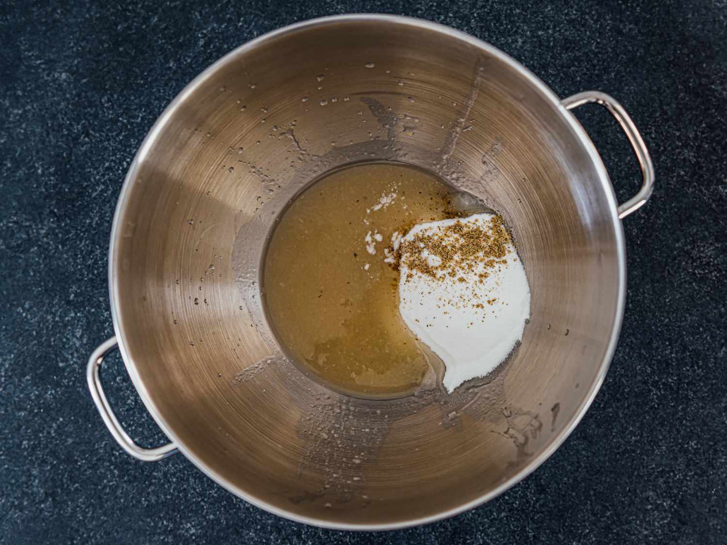 aquafaba, sugar, cardamom, and cream of tartar in the bowl of a stand mixer