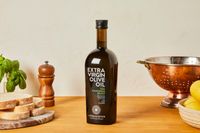 A bottle of extra-virgin olive oil on a kitchen countertop.