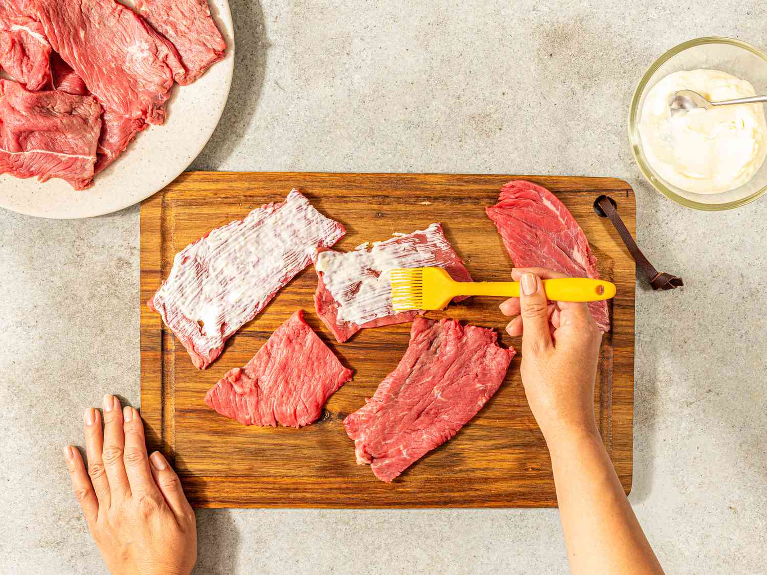 Spreading mayo on meat