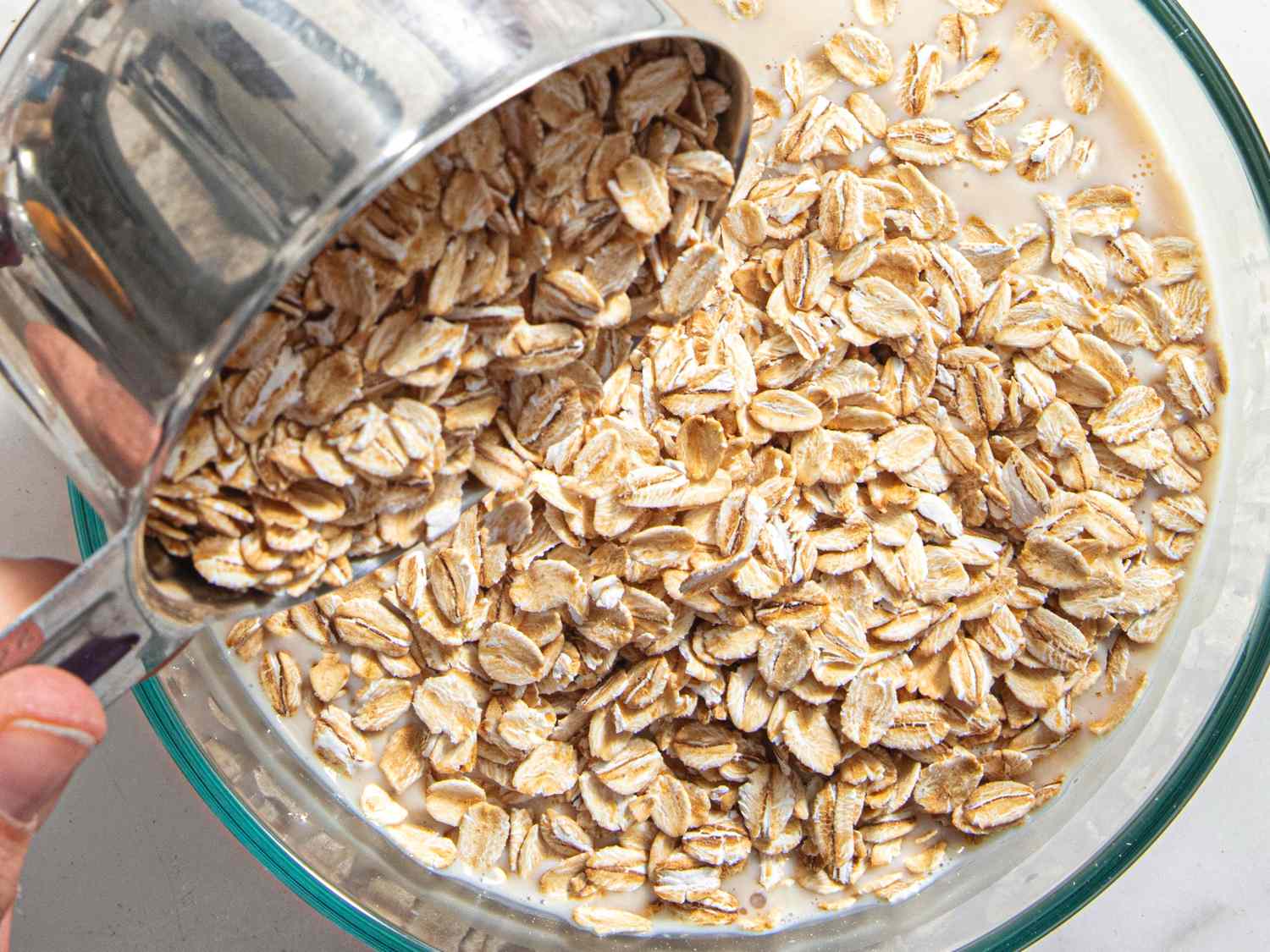 Overhead view of dumping oats into a bowl 