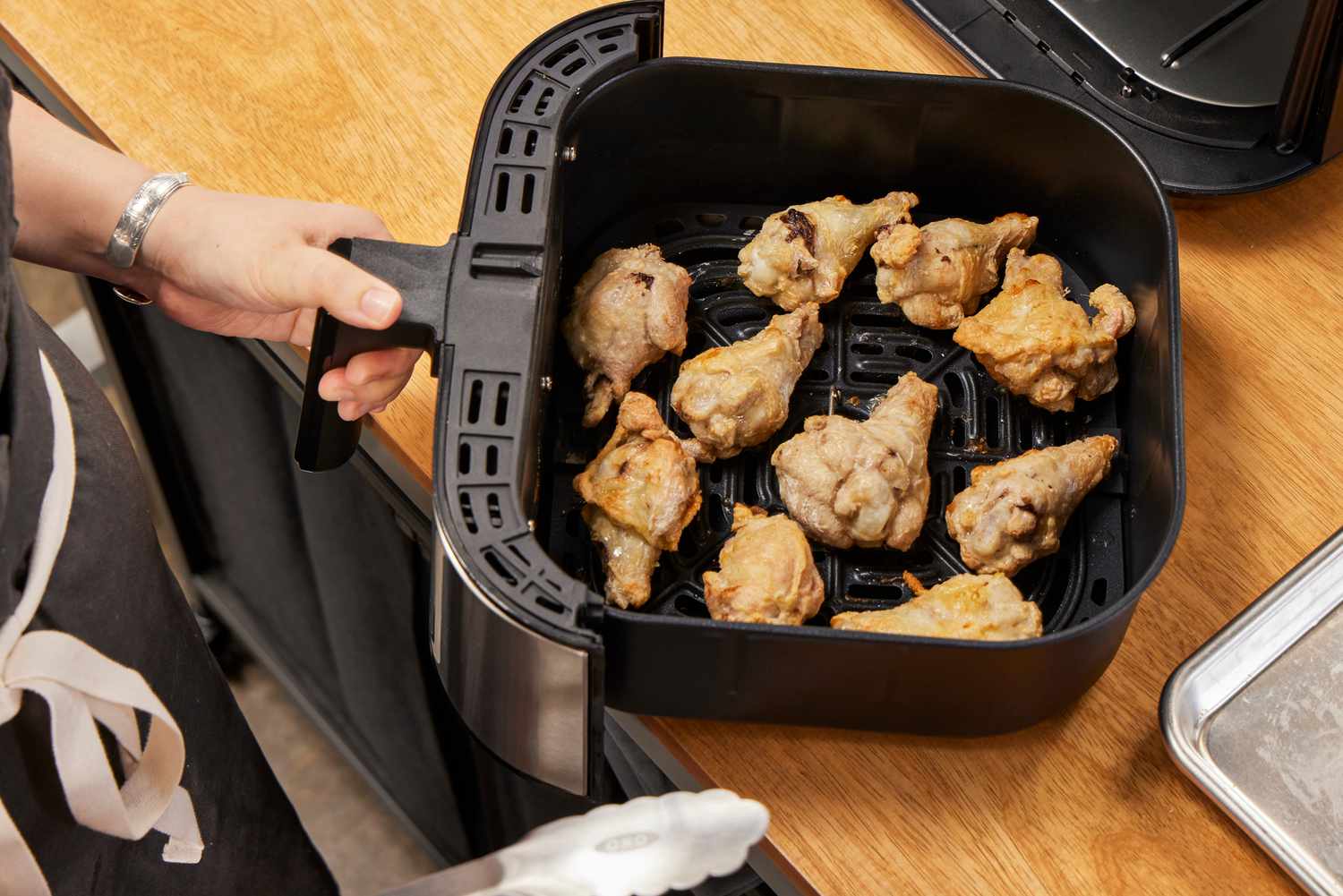 Wings in the Instant Vortex Plus 6QT XL Air Fryer basket on a wooden surface
