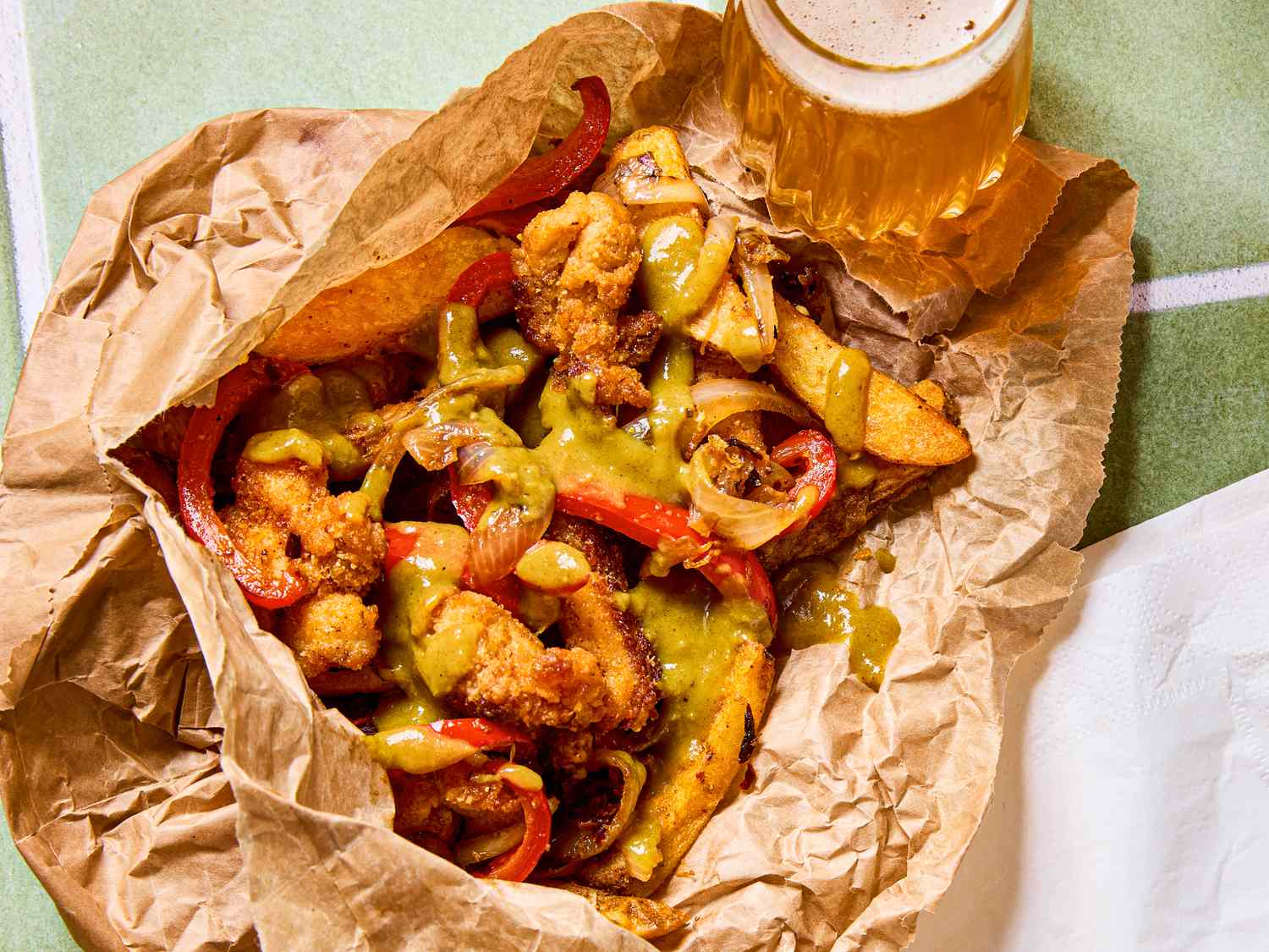 Crispy fried chicken and chips served with curry sauce and a glass of beverage
