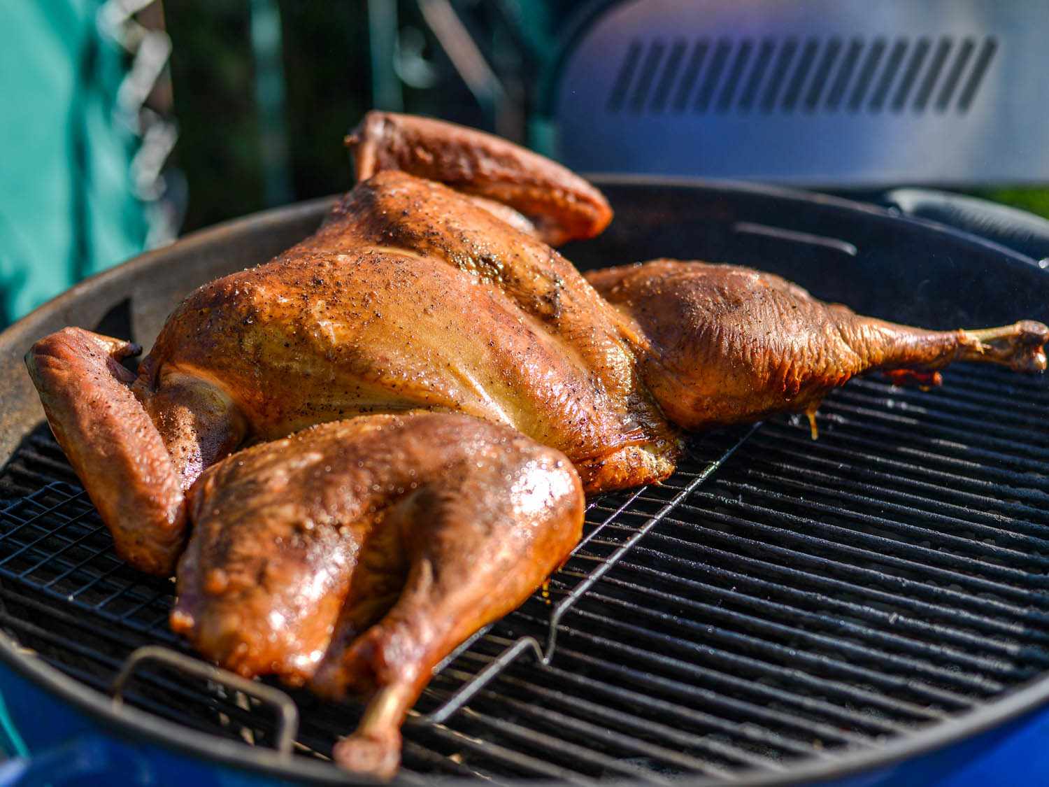 A cooked butterflied turkey on a grill.