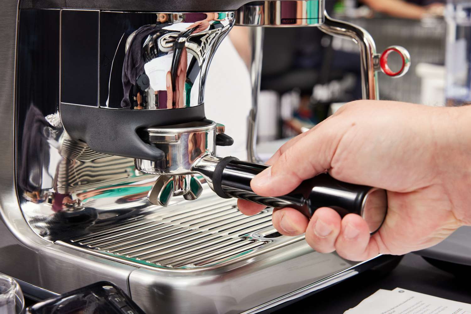 A person adjusting the portafilter on the Breville Barista Touch Impress Espresso Machine with Grinder