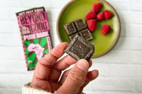 A hand holding a piece of the Beyond Good Pure Dark 70%