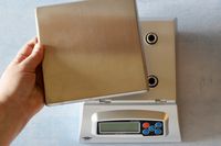 A person removing the platform of the My Weigh kitchen scale.