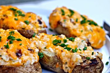 Close up of grilled, loaded twice-baked potatoes, ready to serve.
