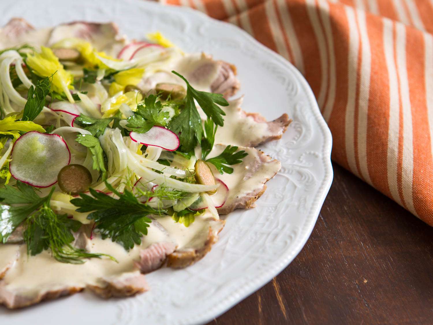Side view of a plate of pork tenderloin vitello tonnato.