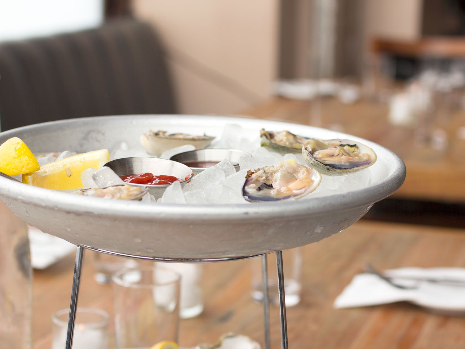 A round tray holding shucked clams on a bed of ice.