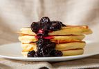 A stack of lemon ricotta pancakes topped with a blueberry compote