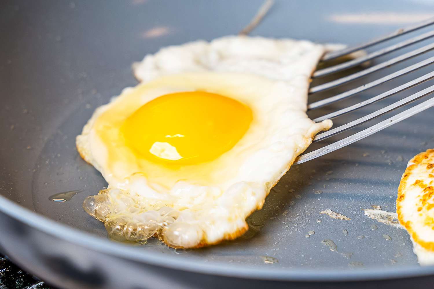 An egg being cooked in a pan from the GreenPan Valencia Pro Ceramic Nonstick 11-Piece Cookware Set