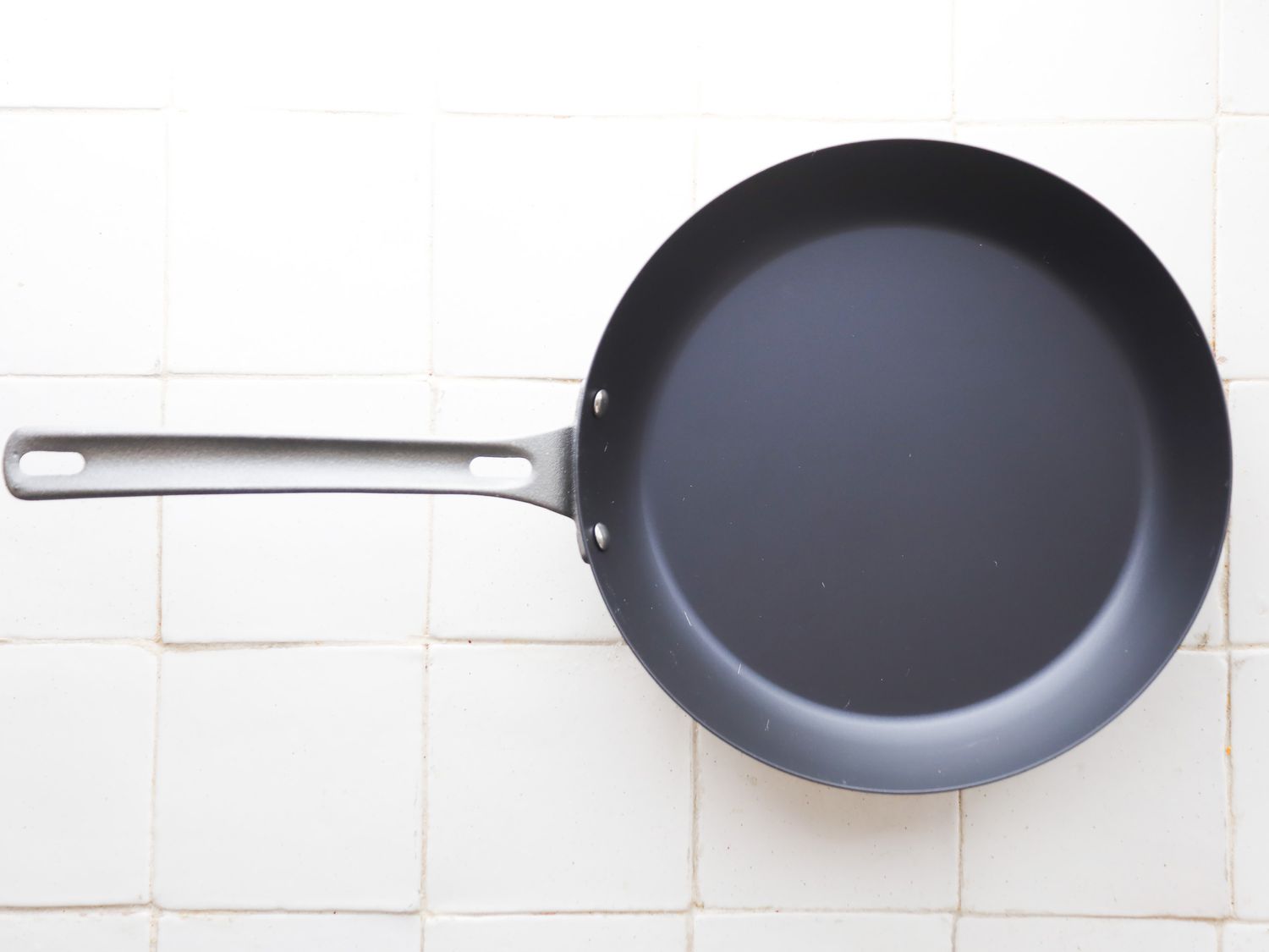 misen carbon steel pan on a white tile surface