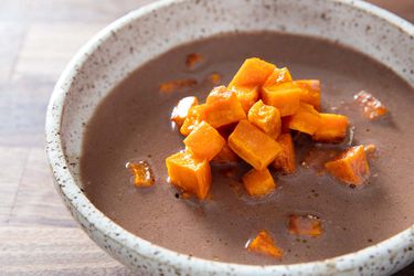 A bowl of Cherokee puréed nut soup topped with sweet potato.