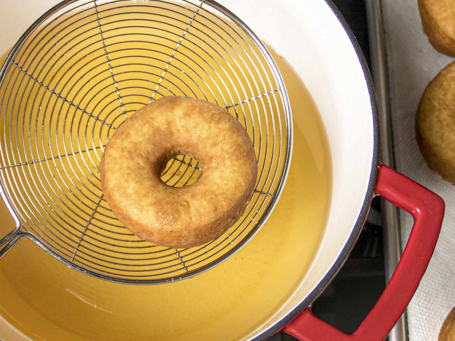 lifting potato doughnut from frying