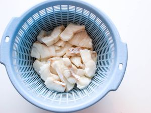 Water-velveted fish resting in a blue strainer.