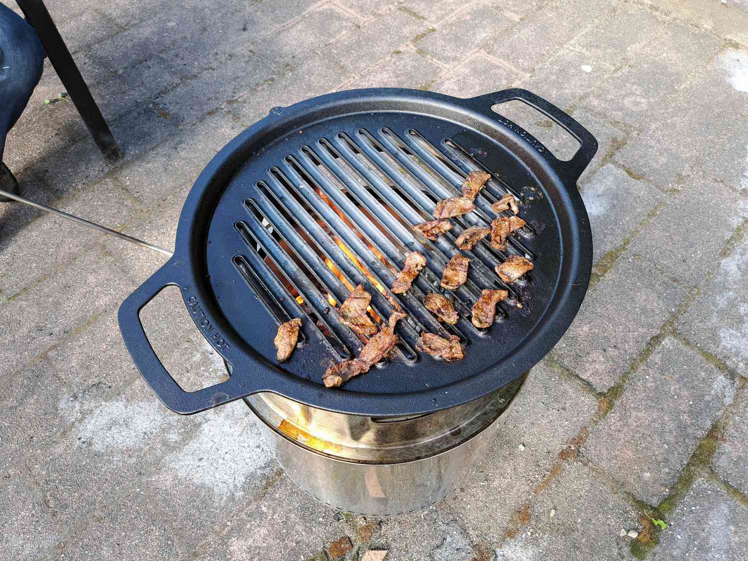 cooking thinly sliced, marinated meat on the solo stove with the grill and hub