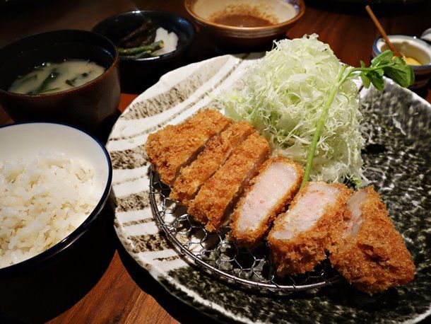 Katsukura's juicy tonkatsu set lunch of sliced fried pork cutlet, shredded cabbage, and bowl of rice on the side