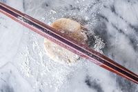 Earlywood French Rolling Pin on a floured dough on a marble surface