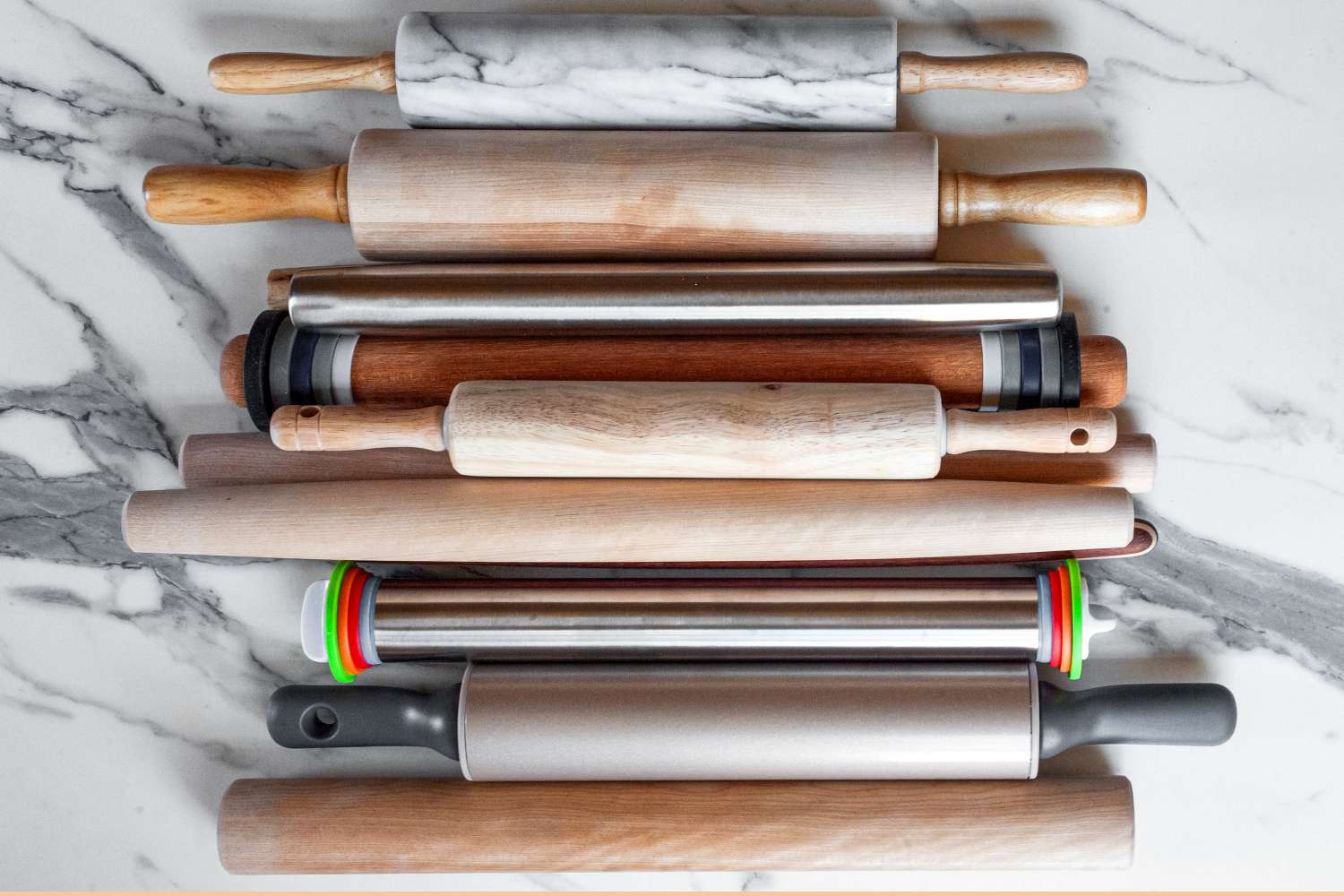 Assorted rolling pins arranged on a marble surface
