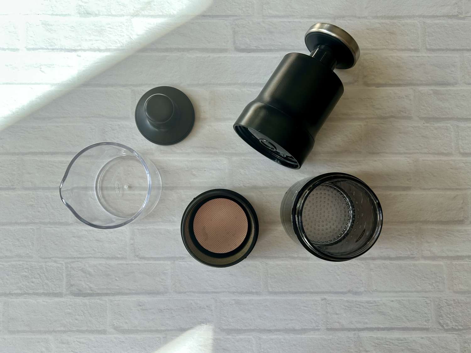 The parts of the OXO Rapid Brewer laid out on a brick surface