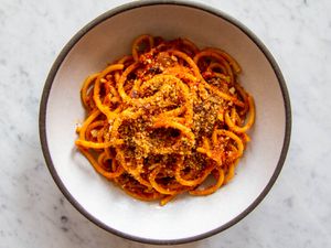 A white bowl with a dark gray rim holding a serving of Sicilian Pasta With Anchovies and Toasted Breadcrumbs, Pasta c'Anciuova e Muddica Atturrata