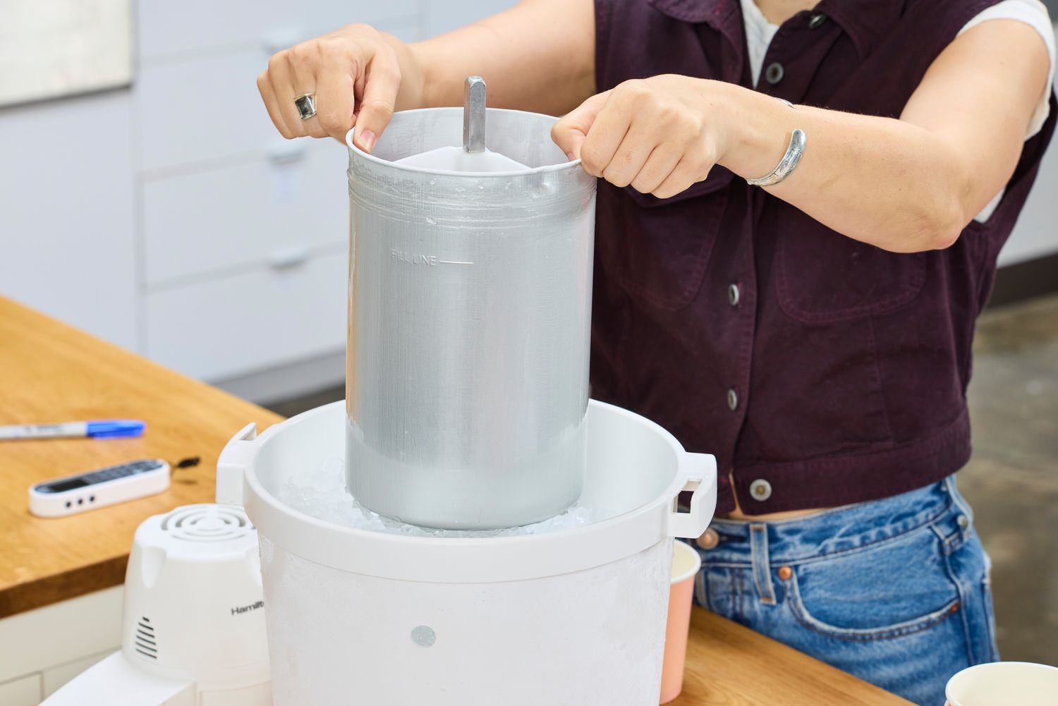 A person placing a bucket into the Hamilton Beach Automatic Ice Cream Maker