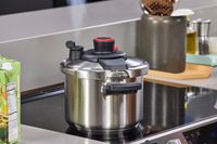 The T-Fal Clipso Pressure Cooker on an induction stove in a kitchen