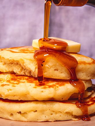 Side view of pouring syrup on pancakes