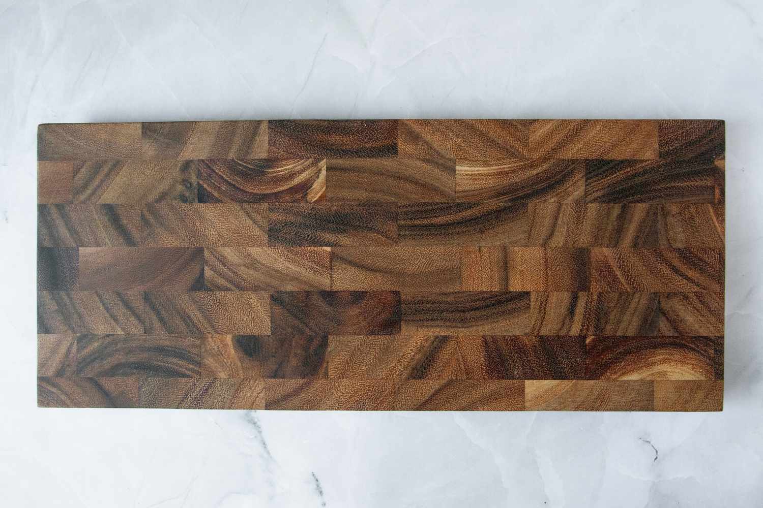 An overhead view of the Ironwood Bowery End-Grain Board on a marble background.