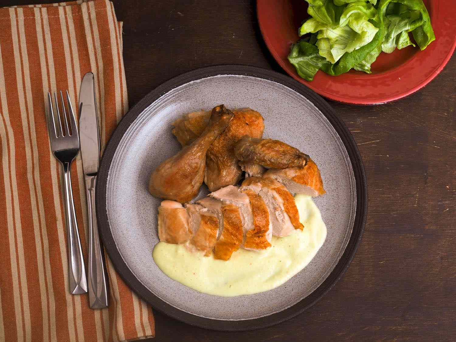 An overhead shot of a plate of roasted chicken with soubise sauce.