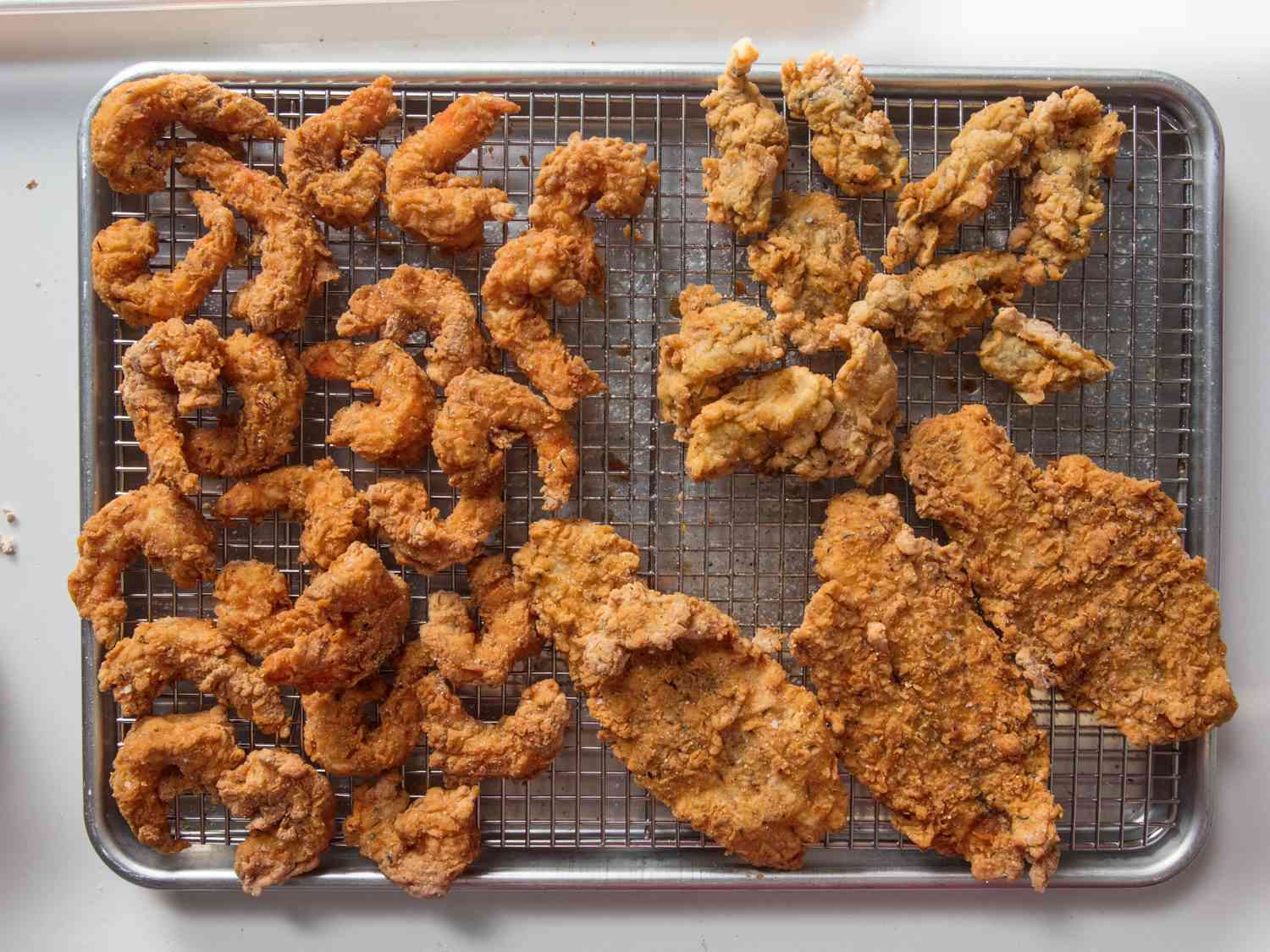 Overhead shot of fried seafood on a wire rack.