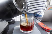 Coffee being poured from the Ratio Six Coffee Maker's carafe into a mug.