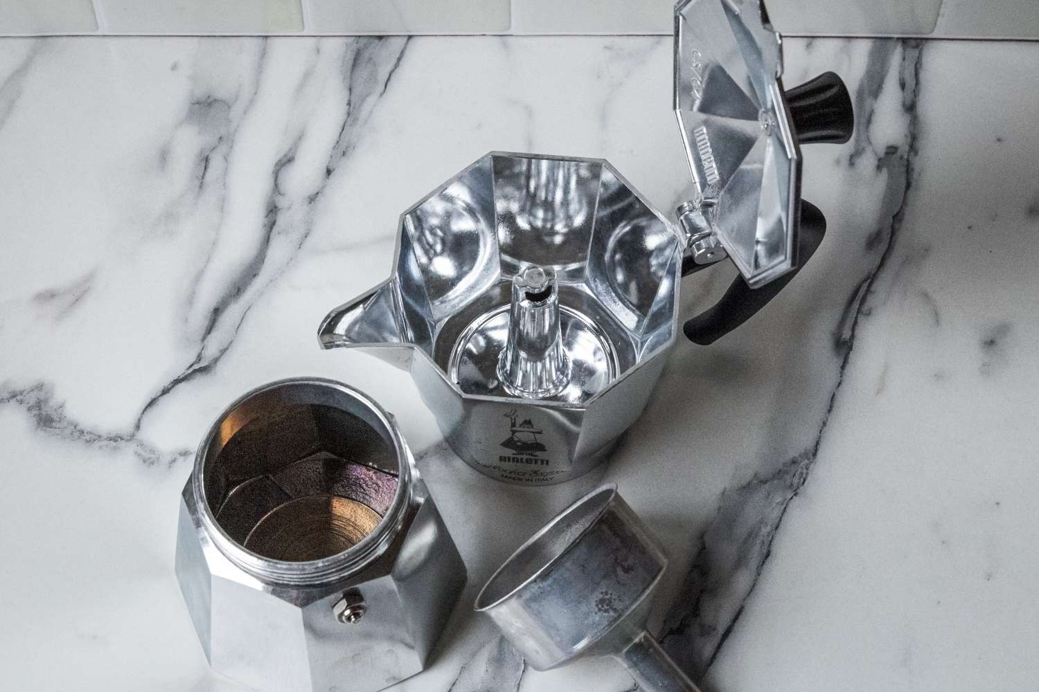 The disassembled parts of the Bialetti Moka Express moka pot.