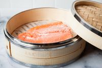 Steamed salmon fillet in a bamboo steamer