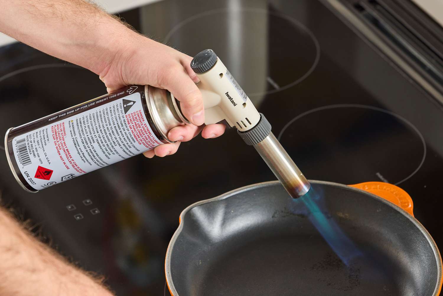 a person heating a skillet with a propane torch