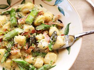 A plate of homemade ricotta asparagus with fresh asparagus, prosciutto, and Parmigiano-Reggiano.