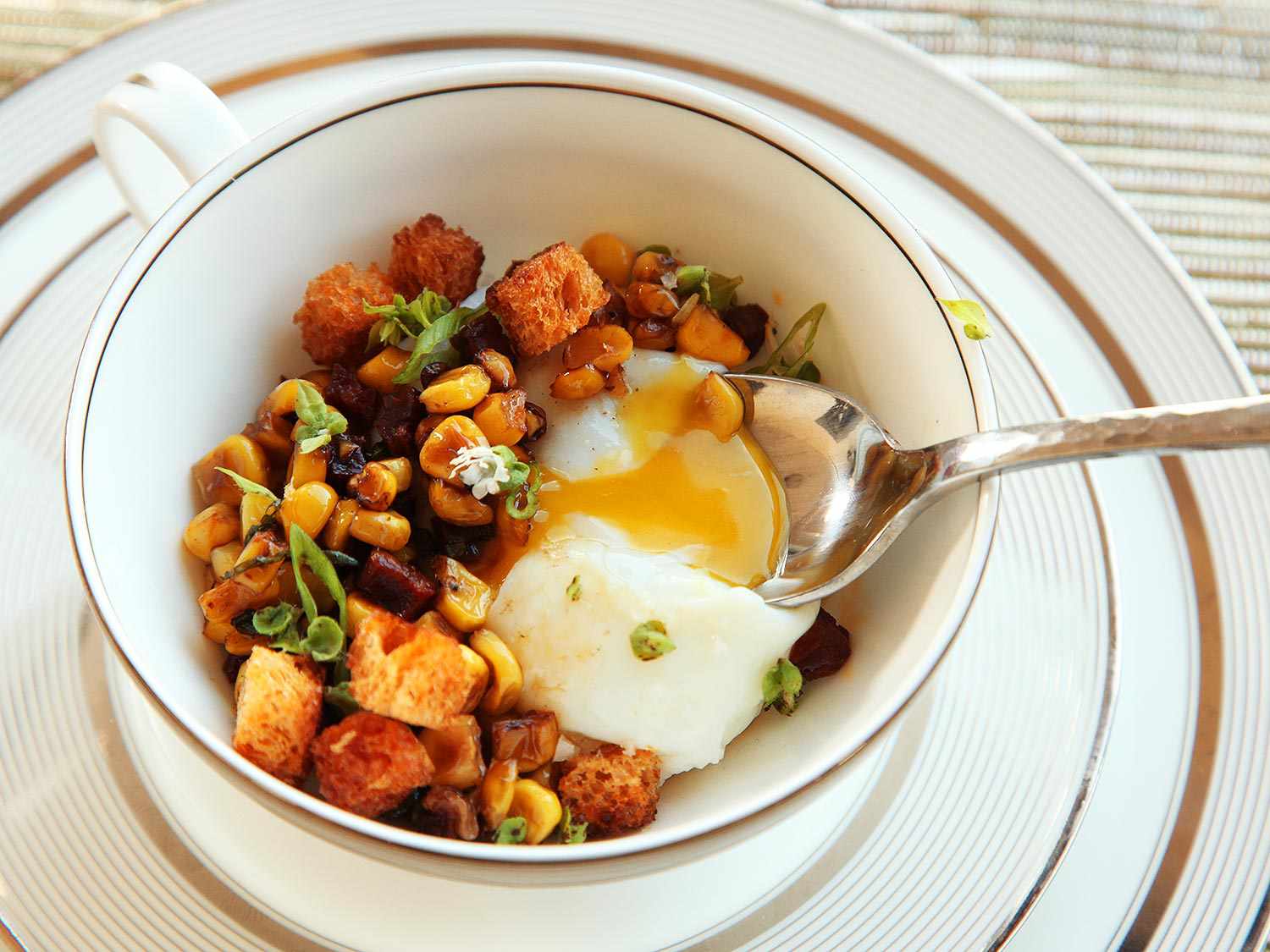 Egg cooked with runny yolks, served with chorizon, corn, and brioche croutons