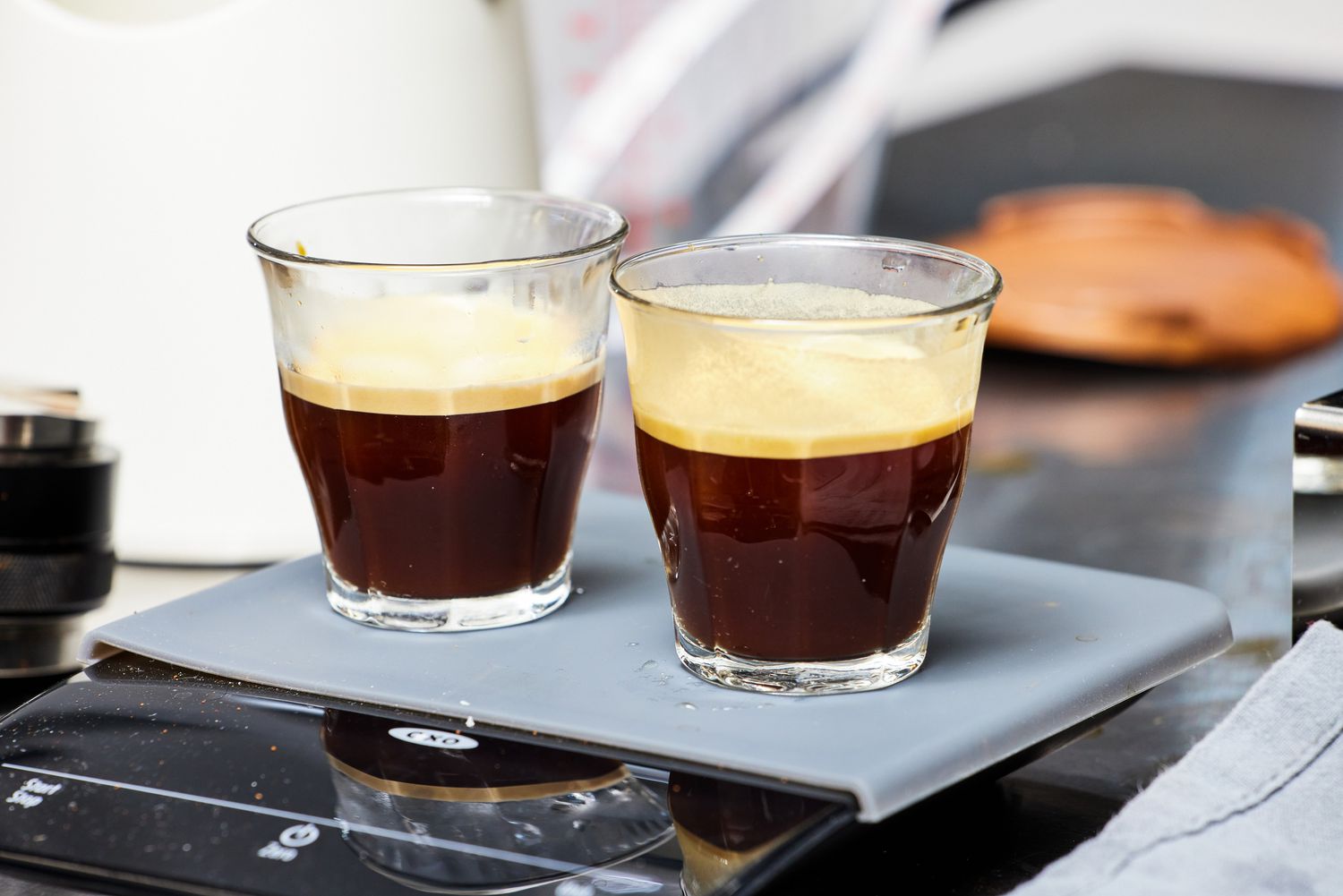 Two glasses with espresso on a grey tray