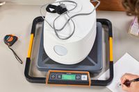A person weighs the Cuckoo 6-Cup Micom Rice Cooker