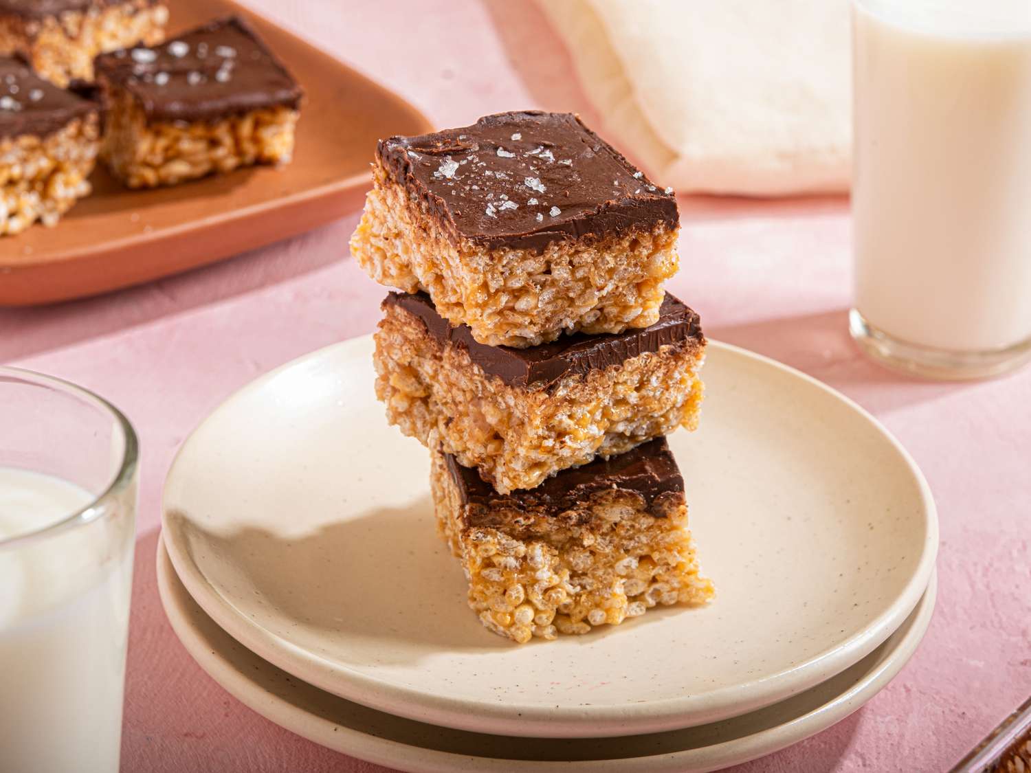 Stacked dessert bars with a chocolate topping on a plate