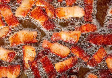 Overhead view of lardons cooking in skillet