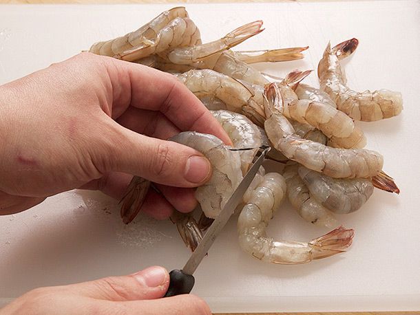 Deveining a pile of raw shrimp for Spanish-style garlic shrimp.