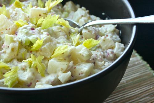Bowl of Classic Potato Salad with a mayonnaise dressing, garnished with celery leaves